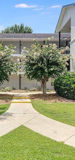 a walkway leading to an apartment building with white siding and a gray roof at Dothan Farms, Dothan, AL, 36305