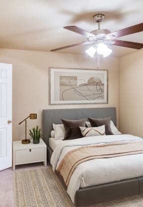 a bedroom with a ceiling fan and a bed at Village Oaks Apartments, Austin, Texas