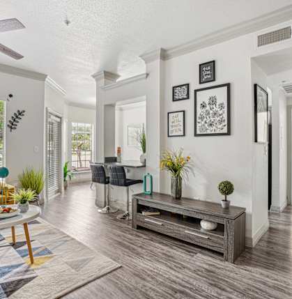 A living room with a yellow chair and a wooden coffee table.