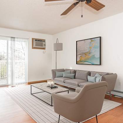 Grand Forks, ND Vista Apartments.  A living room with a couch, chair, tv, and a sliding glass door