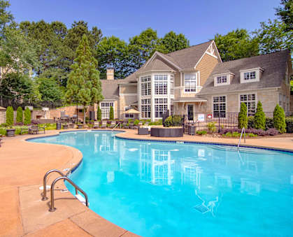 A large swimming pool in front of a house.