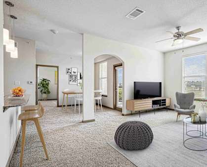 A living room with a television, chairs, and a table.