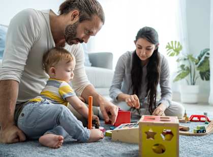 A family playing with toys on the floor.