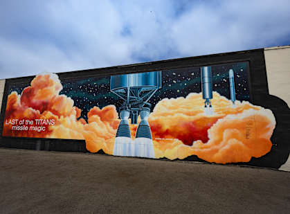 a mural on the side of a building with an image of a space shuttle with