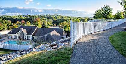 a view of a house from behind a fence and a pool