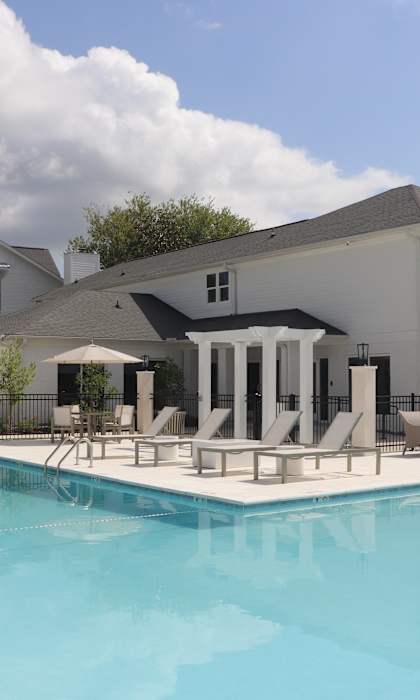 A large swimming pool in front of a white building.