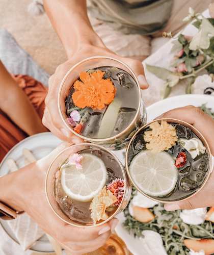 three cups of drinks with flowers on a table