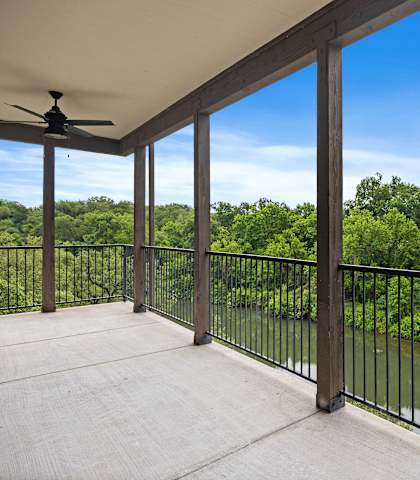 a balcony with a view of a river and trees at Waters Edge Apartment Homes, Georgetown