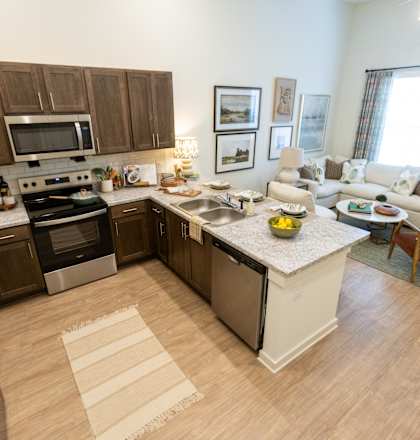 A kitchen with a refrigerator, oven, and sink.