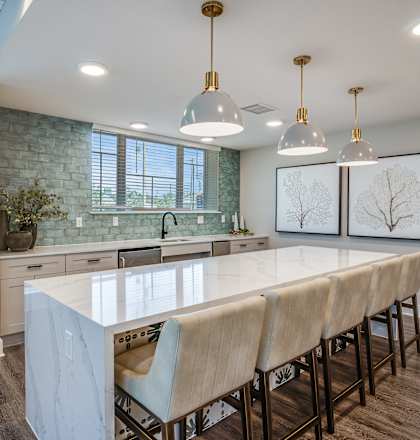 A kitchen with a long table and chairs.