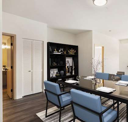 a dining room table with blue chairs in front of a living room  at Shoreline Village, Richland, 99352