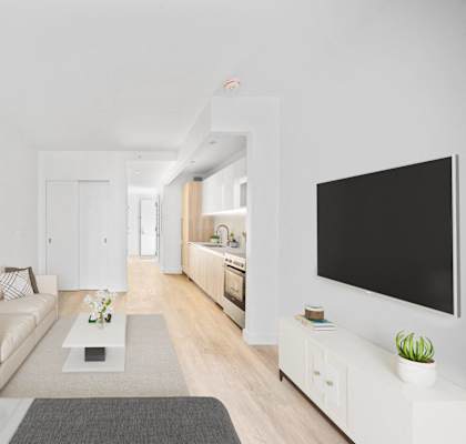 A modern living room with a white couch, a coffee table, and a large painting on the wall at Aria, New York, 10038.