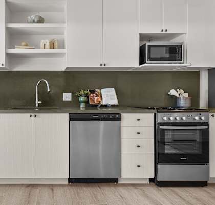 A modern kitchen with white cabinets and a black dishwasher.