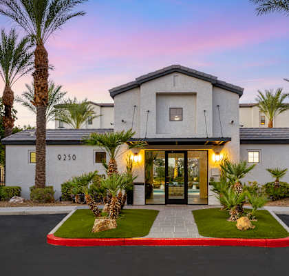 the front of a house with palm trees in front of it