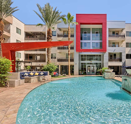 A red building with a pool in front of it.