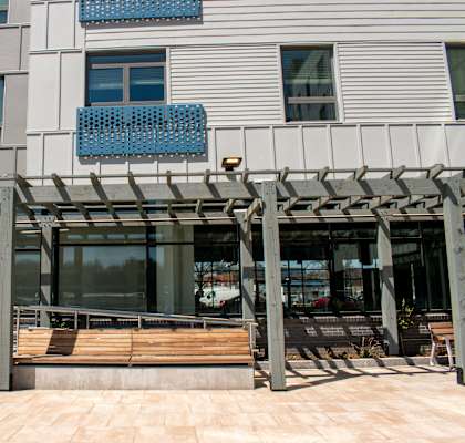 the front of a building with a wooden bench in front