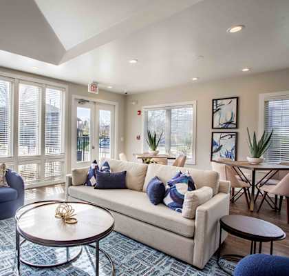 A living room with a couch, chairs, and a coffee table.