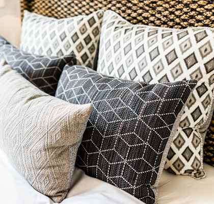 a pile of pillows on top of a bed