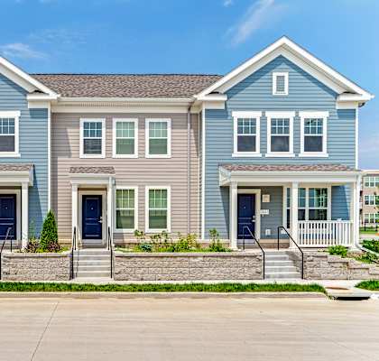 a blue and with steps and a driveway