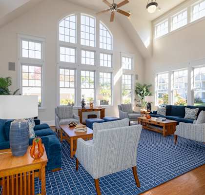A living room with blue chairs and a wooden coffee table.