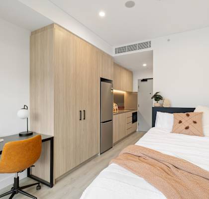 A bedroom with a bed, desk, and chair.