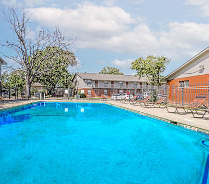A large swimming pool with blue water and sun loungers.