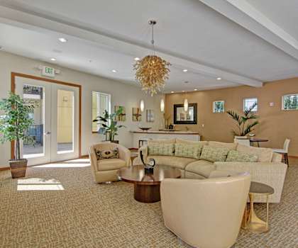 The front office and resident lounge with couches, a TV, and a coffee table at Ondine at Juanita Bay Apartments. 