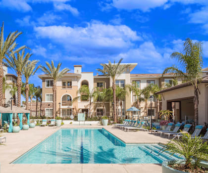 a swimming pool with palm trees in front of a building