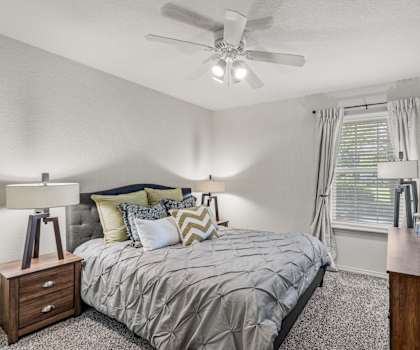 a bedroom with a bed and a ceiling fan