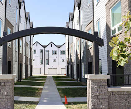 A row of modern houses with a black archway in the foreground.
