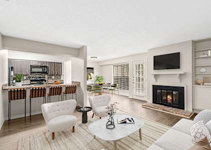 A modern open concept living area with breakfast bar and fireplace at Oakley at Hillcrest in west mobile, al