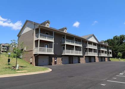 A large apartment complex with a parking lot in front.