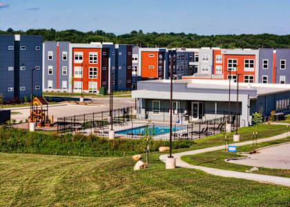 A large building with a pool in front of it.