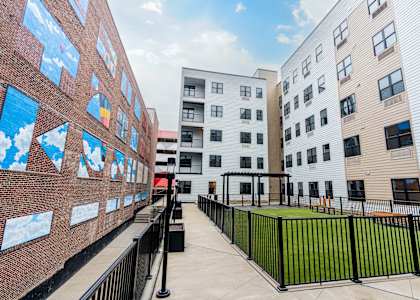 A long corridor with a black fence and a wall with pictures on it at The Gallery Apartment Homes Apartments, Allentown, PA, 18101