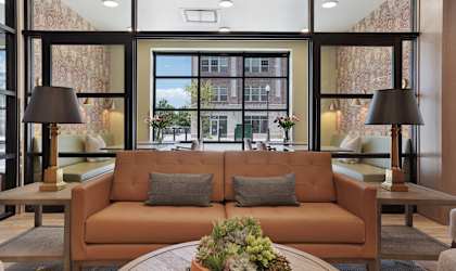 A living room with a large window and a view of a city street.