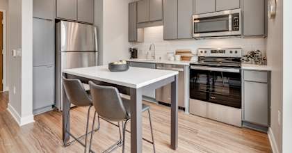 A modern kitchen with a table and chairs.