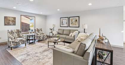 A living room with a grey couch and a coffee table.