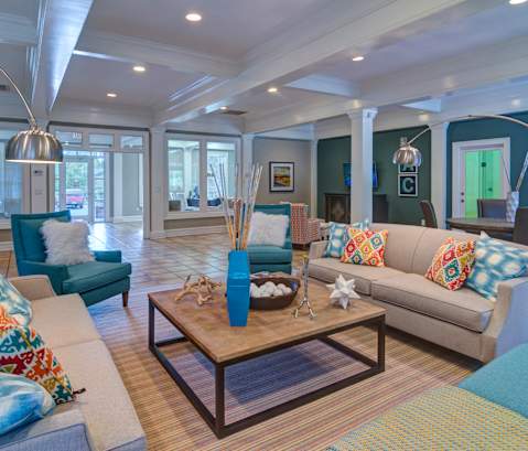 A living room with a sofa, armchair, and coffee table at Austin Chase Apartments, Georgia 31210