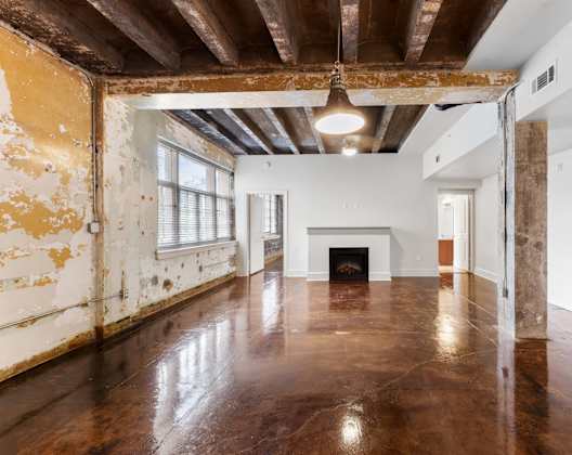 an empty living room with white walls and a fireplace