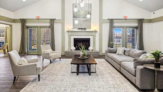 A large, well-lit living room with a fireplace and comfortable seating.