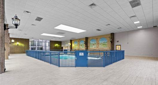 A large room with a long blue table and a pool table.