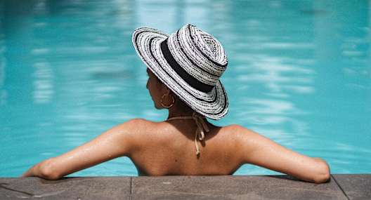 a woman in a swimming pool wearing a hat
