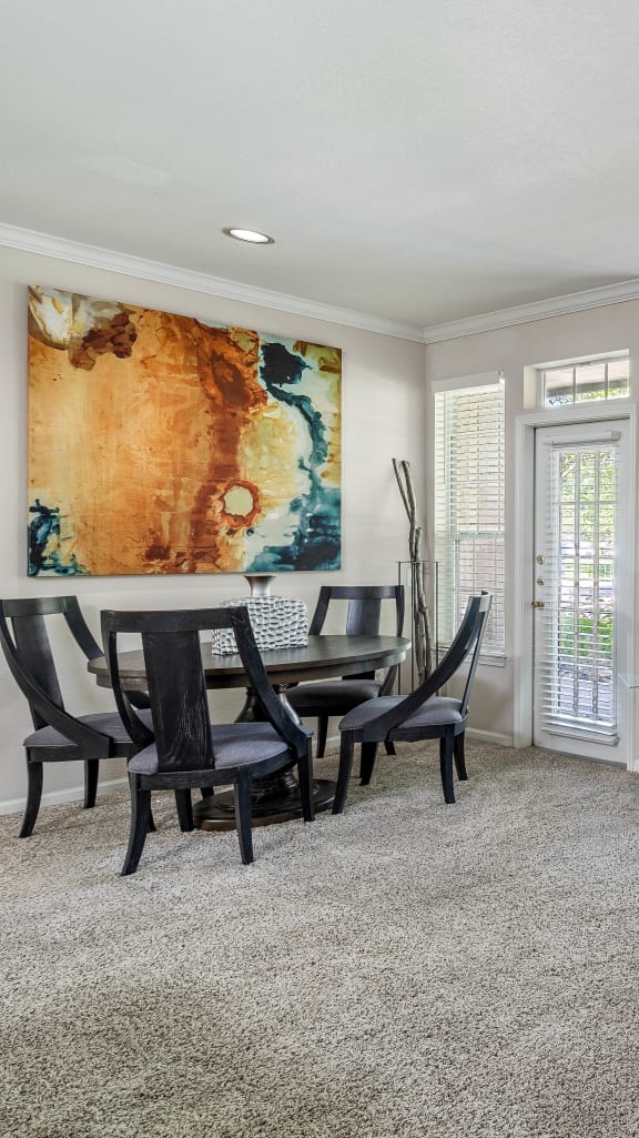 a living room with a couch and a chair in front of a table with a chair and