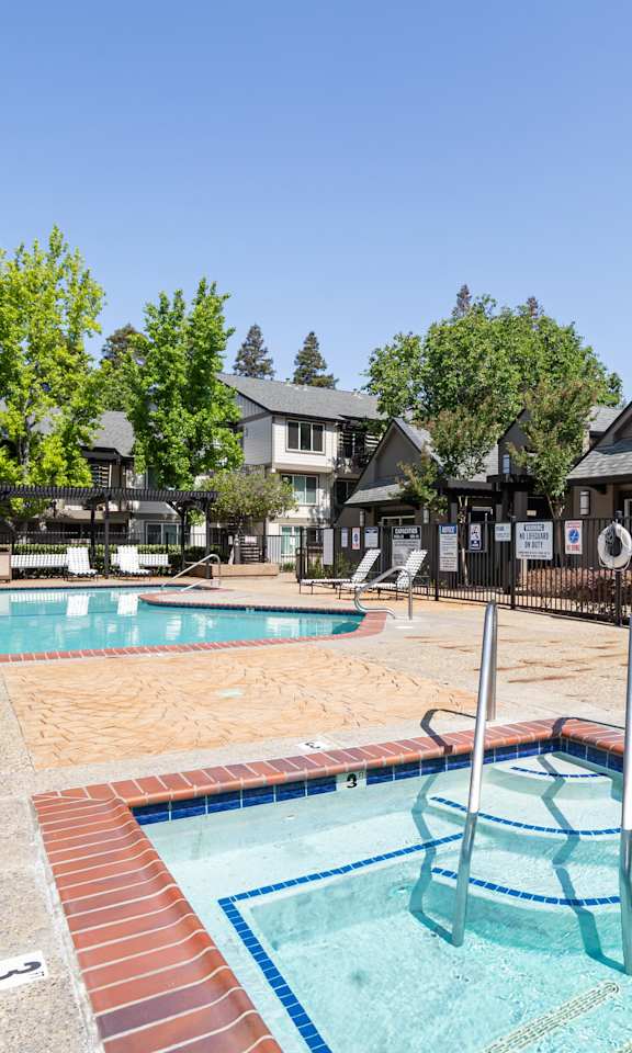 A pool with a slide and a hot tub.