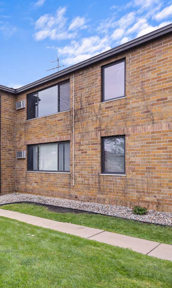 A brick building with a green lawn in front.