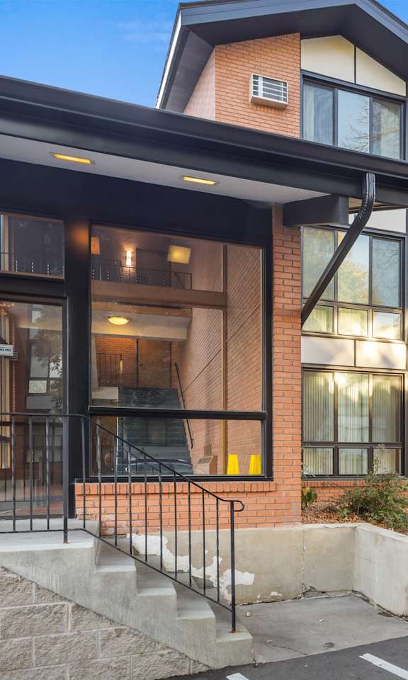 A modern building with a black awning and glass windows.