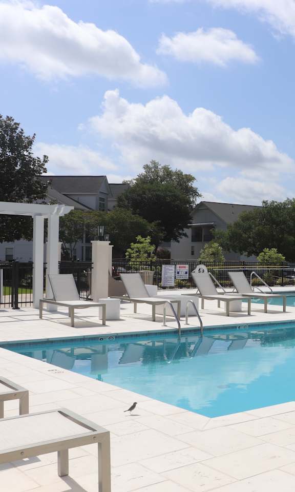 A pool with chairs around it.