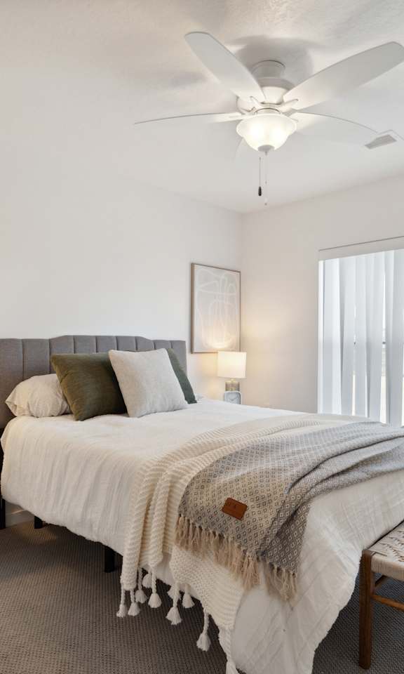 a bedroom with a large bed and a ceiling fan