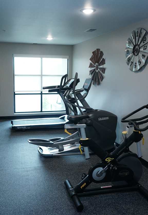 a gym with exercise equipment in a room with a window