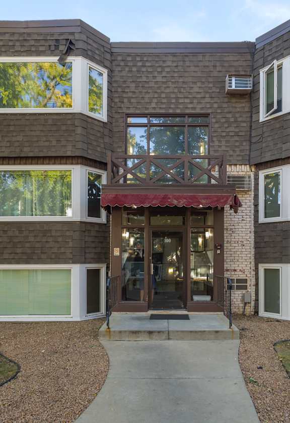 A modern house with a red awning at the entrance.